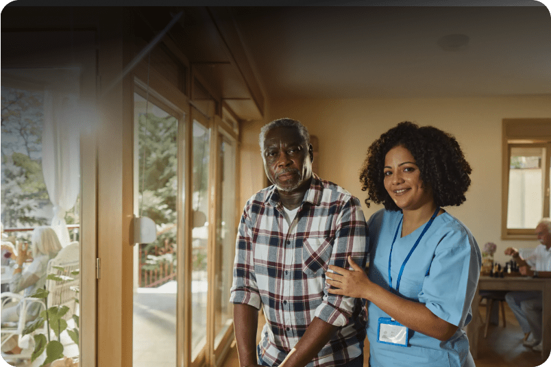 Nurse supporting senior man indoors